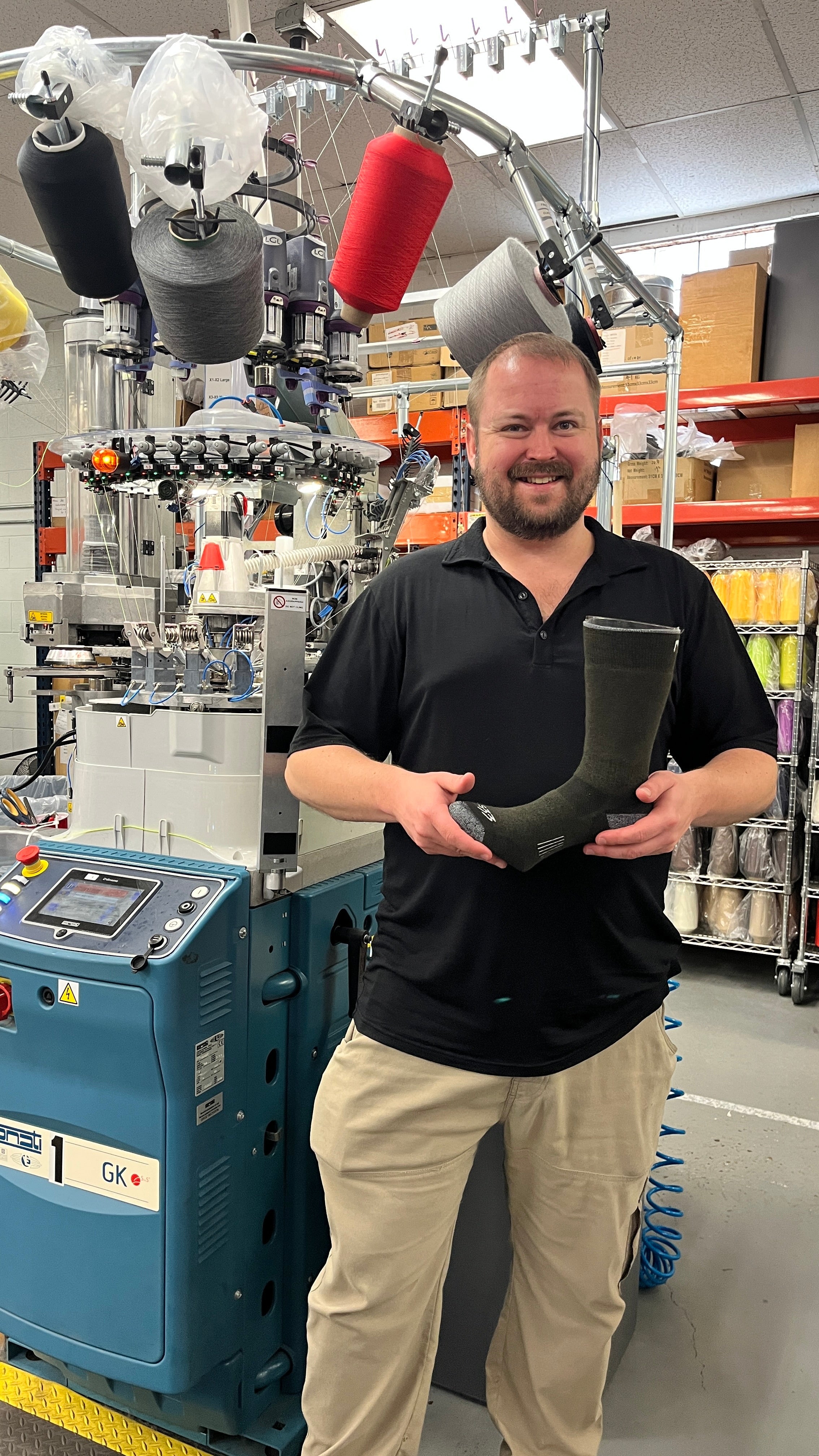 Lawson Glidden, President of Minus33 holds a sock in front of a sock machine in Ashland, New Hampshire.