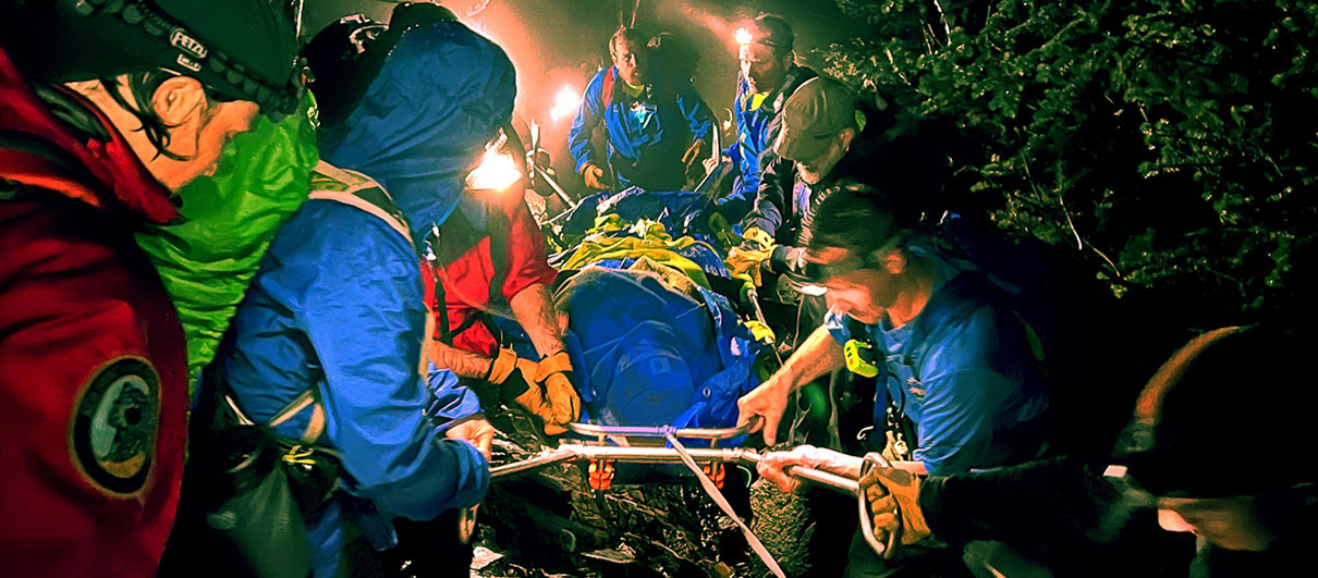 Search and Rescue rangers carry out a patient in the dark