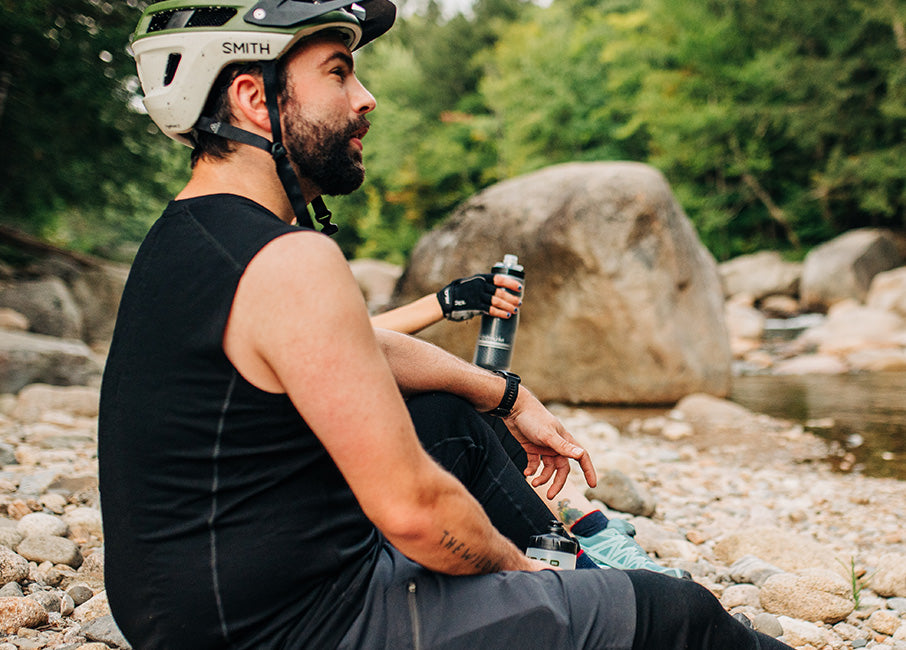 man sitting down wearing a bike helmet and sleeveless tank