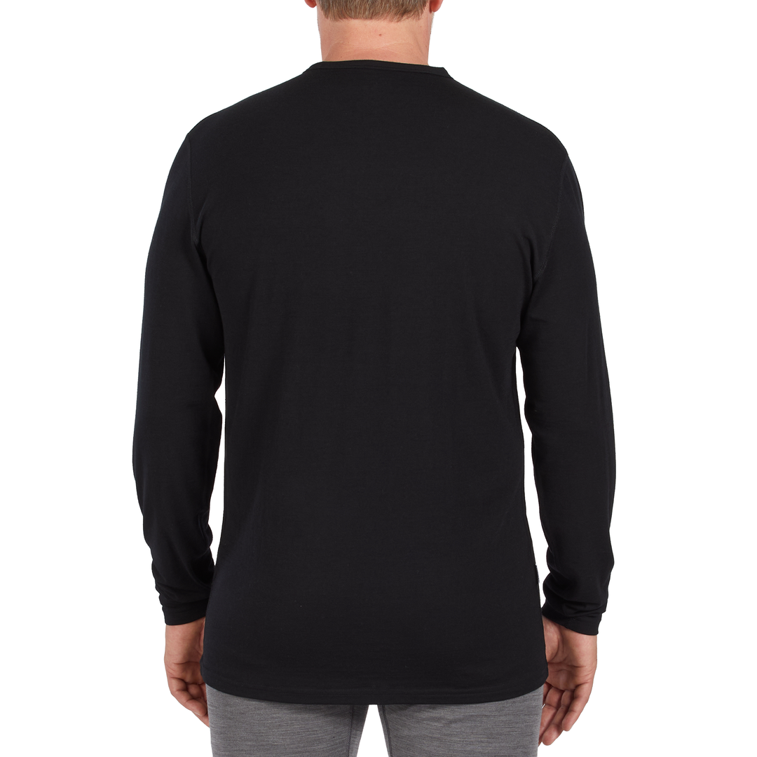 A man models the microweight long sleeved merino wool base layer crew neck top 