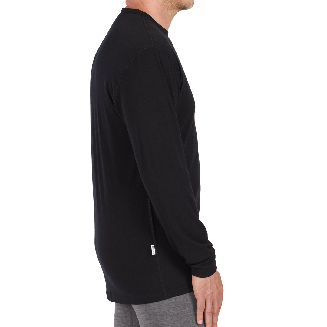 A man models the microweight long sleeved merino wool base layer crew neck top 