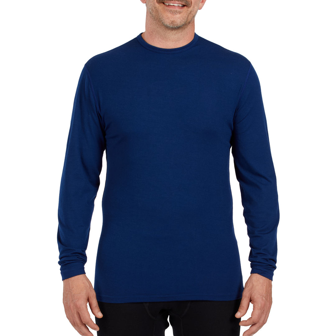 A man models the microweight long sleeved merino wool base layer crew neck top 