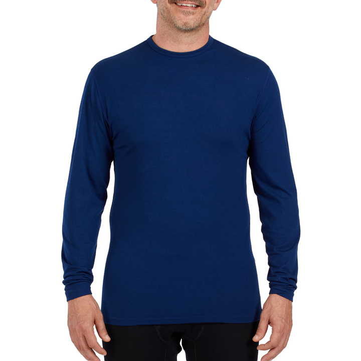 A man models the microweight long sleeved merino wool base layer crew neck top 