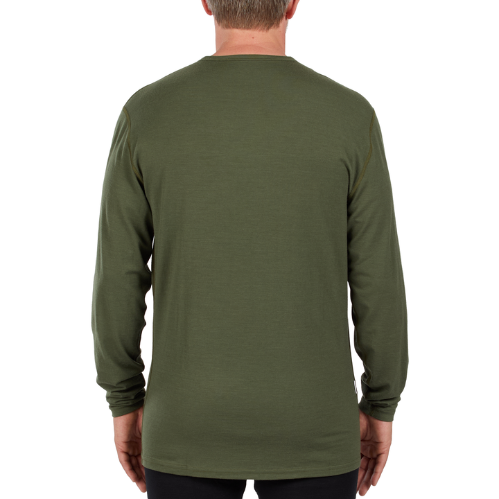 A man models the microweight long sleeved merino wool base layer crew neck top 