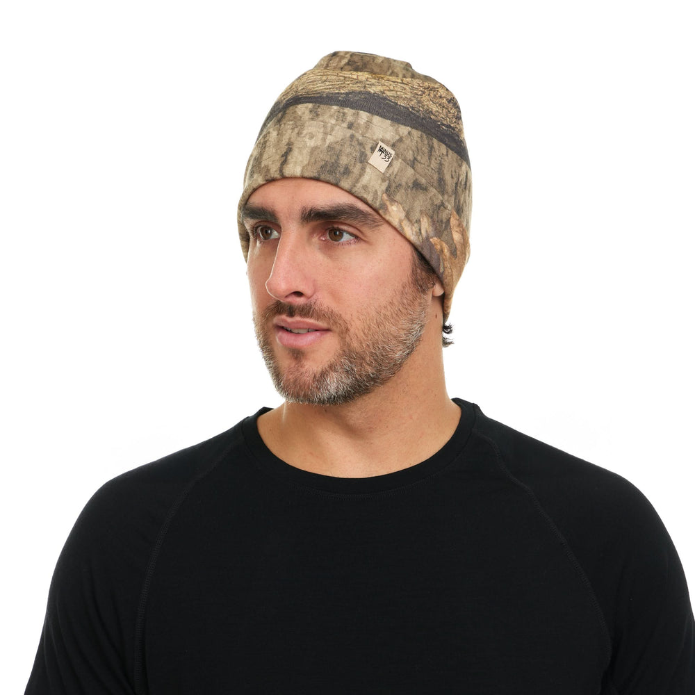 Camouflage merino wool beanie worn on a model, front view #color_mossy-oak-country-roots