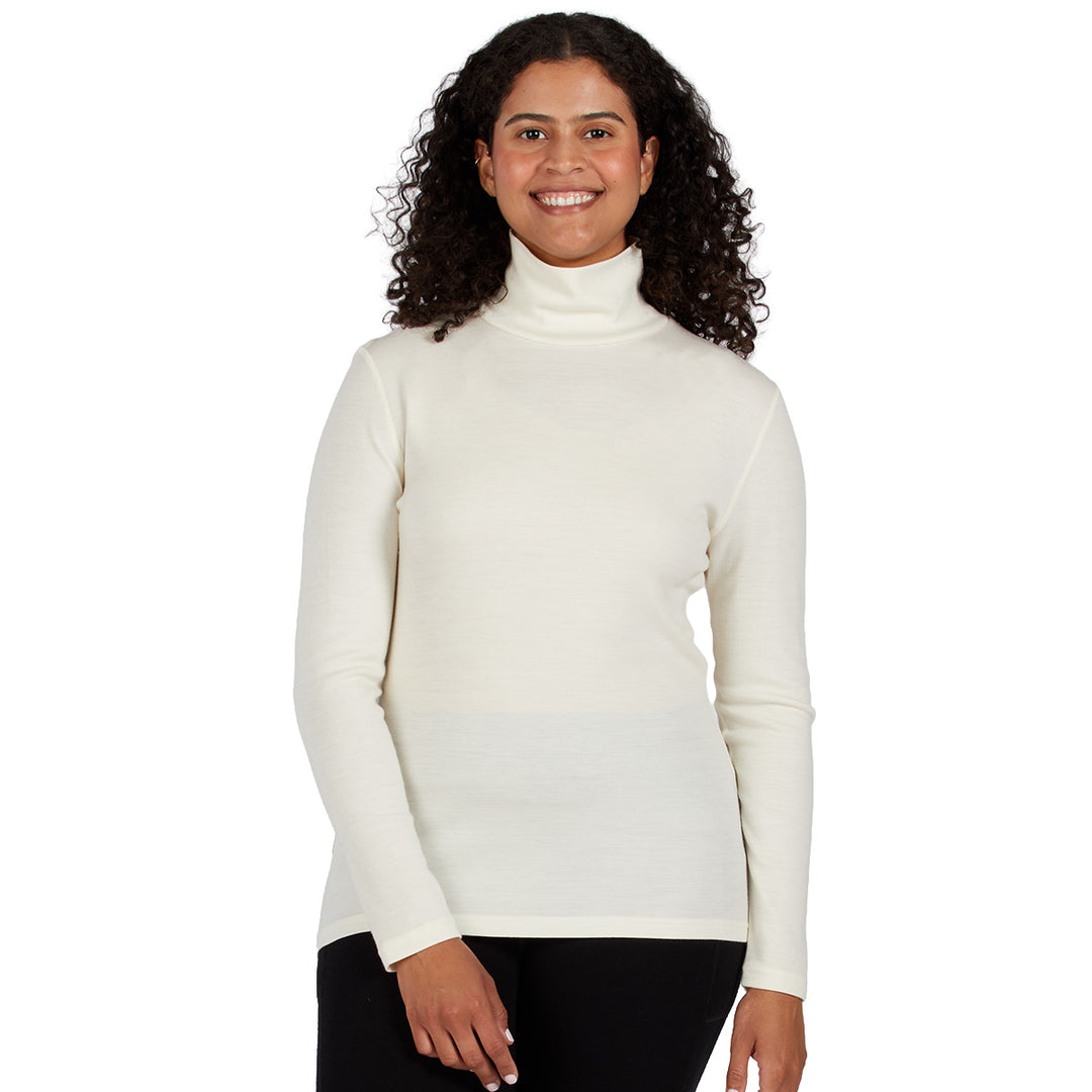 a cream-colored ribbed turtleneck sweater and black pants, merino wool #color_natural-cream