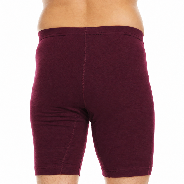 A close-up back view of a man wearing fitted burgundy boxer briefs against a plain white background. 
