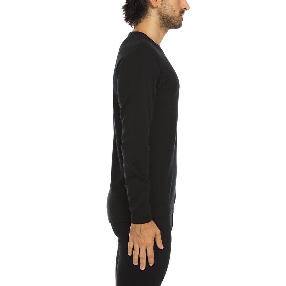 A man models a super soft, long sleeved merino wool thermal base layer crew. Whether you're wielding an ice axe on a near-vertical ice sheet or taking the dog for a walk on a cold afternoon this garment will perform to your satisfaction. #color_black