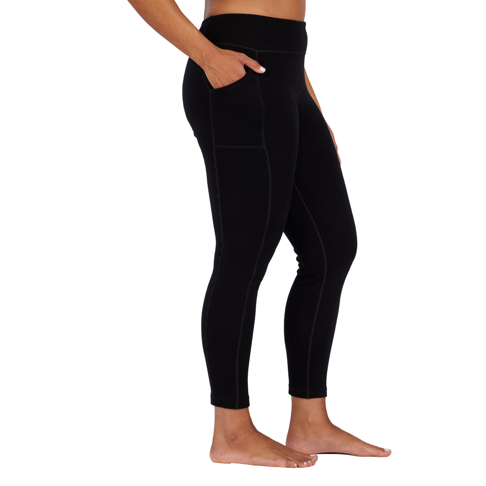 womens black expedition weight leggings side profile with hand in their pocket #color_black